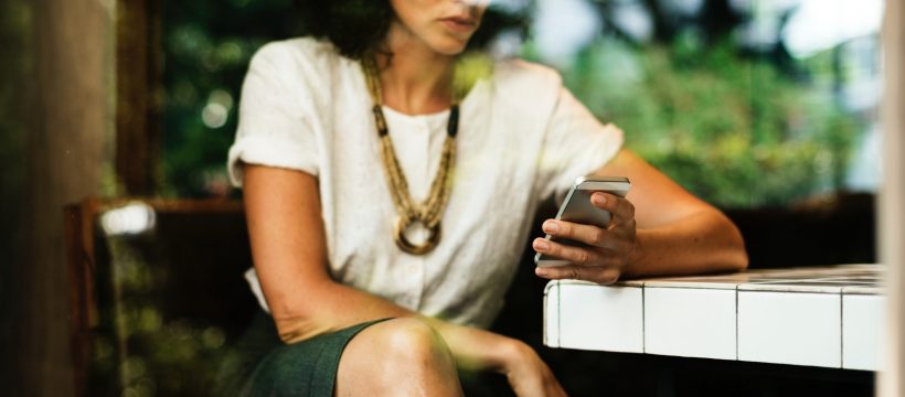 Seated woman looking at smartphone.