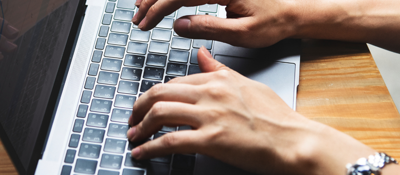 A woman typing on a laptop.