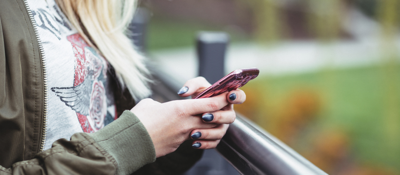 A young woman uses her phone to report suspicious activity to Crime Stoppers.